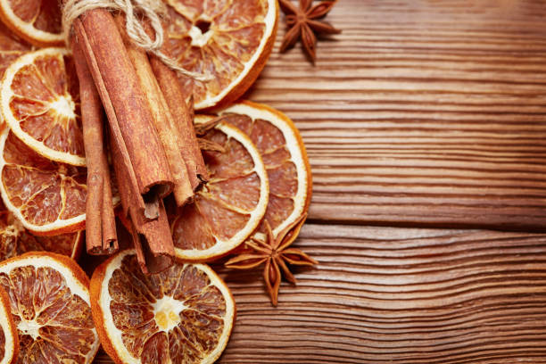 istock dry oranges with cinnamon on wooden background with copy space 1077864654
