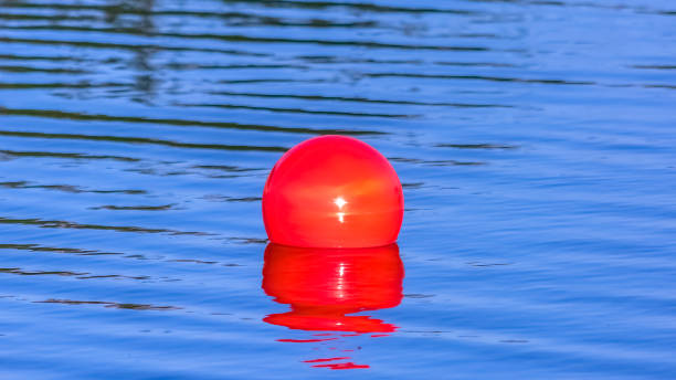 istock Bright red ball floating on the calm Oquirrh Lake 1077872642