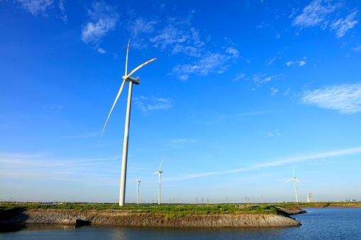 Wind turbines under blue skies and white clouds