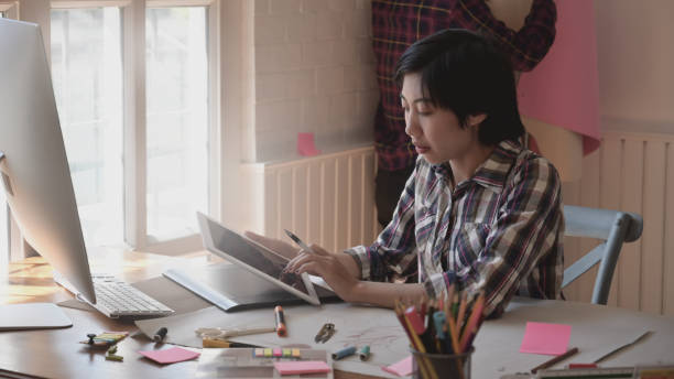 istock Fashion stylish designer using tablet as sketching in studio. 1077881052