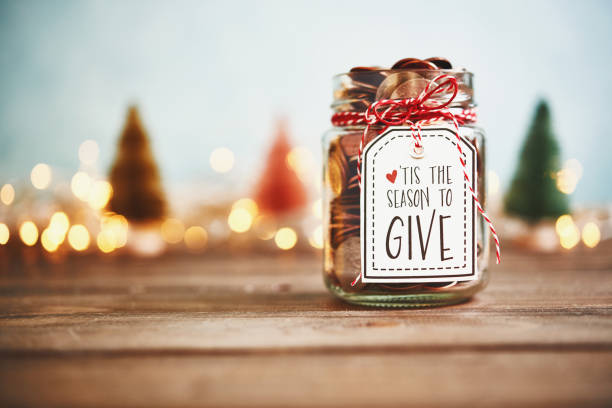 es la temporada para dar. tarro de donación con dinero - seasonal holidays fotografías e imágenes de stock