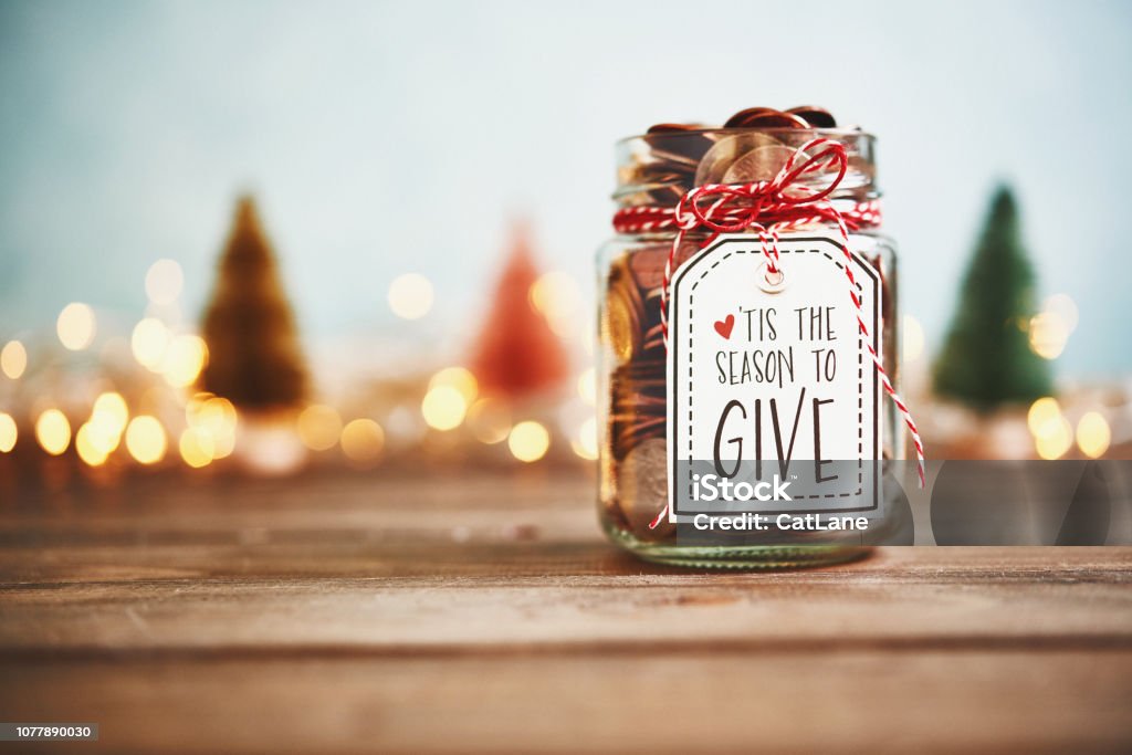 It's the season to give. Donation jar with money Christmas Stock Photo