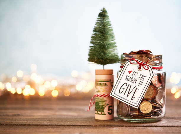 It's the season to give. Donation jar with money It's the season to give. Donation jar with money gift tag note photos stock pictures, royalty-free photos & images