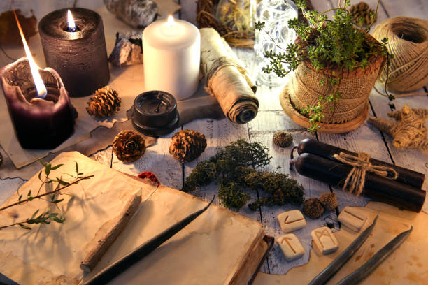 istock Open book, black and white candles, runes and succulent on witch table 1077890464