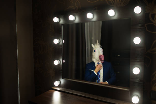 istock Glamour man in elegant suit and funny mask 1077895786