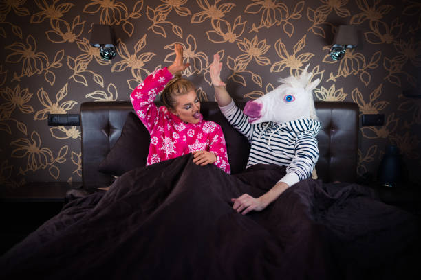 istock Young woman with freaky man in comical mask 1077895826