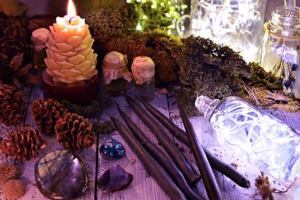 istock Black candles, cones, nature elements and shining bottle on table 1077897646