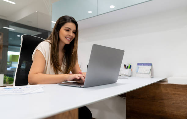 istock Successful business woman at her office typing something on laptop while smiling 1077900910