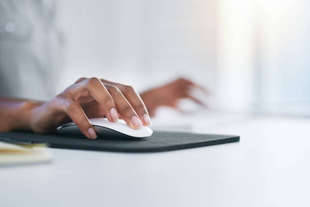 Scrolling and clicking through a world of opportunity Closeup shot of an unrecognizable woman using a computer mouse in an office click link stock pictures, royalty-free photos & images