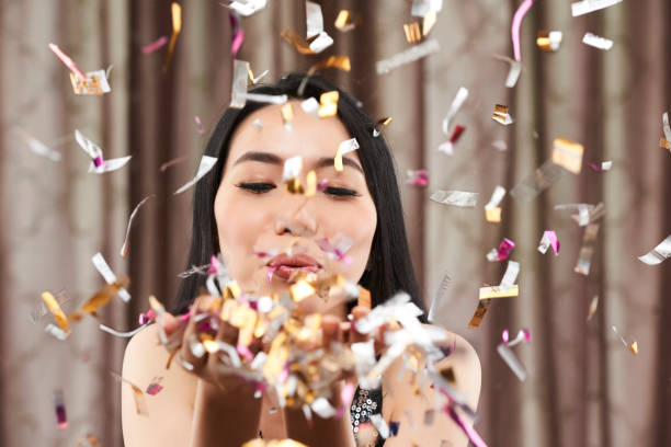 istock Woman blowing out confetti 1077906386