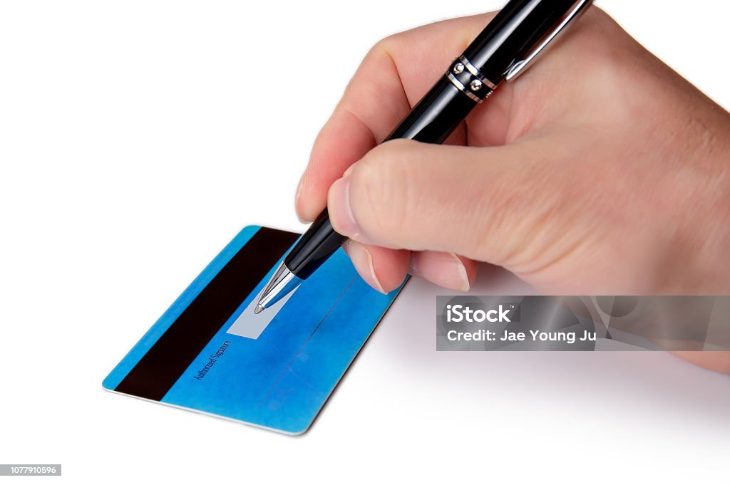 Businessman's hand signing the back of his credit card. Adult Stock Photo