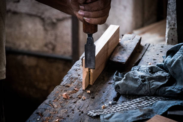 istock Hands of carpenter with chisel in the hands on the workbench in carpentry 1077920546
