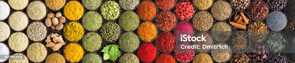 Various spices and herbs as a background. Colorful condiments in cups, top view bright Indian spices and herbs in cups, top view. background for packing with condiments. Spice Stock Photo