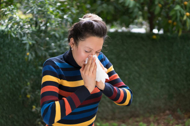 istock Woman blowing her nose on a tissue 1077923330