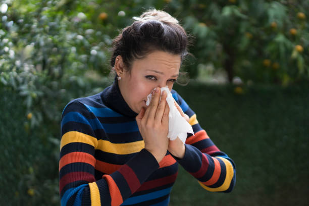 istock Woman blowing her nose on a tissue 1077923342