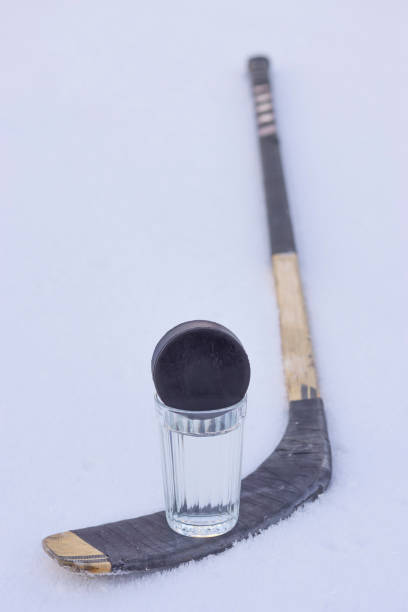 istock Hockey puck on glass and stick 1077929582