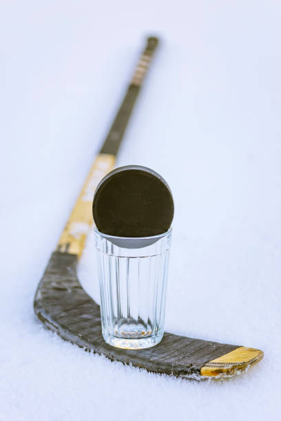 istock Hockey puck on glass and stick 1077934950