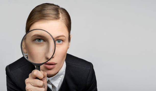 istock girl in the office with a magnifying glass 1077938342