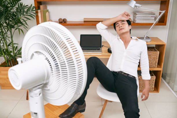 istock Businessman suffering from heat at office 1077938862