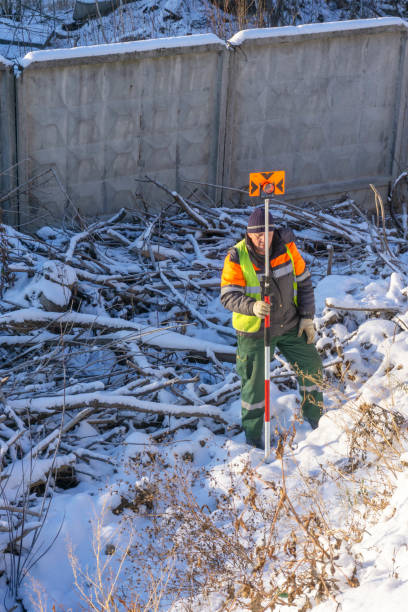 istock Surveyor's assistant holds a measuring prism for cadastral work 1077940644