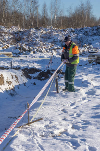 istock A worker at a construction site shields trenches with a signal tape for cadastral surveying. 1077940668