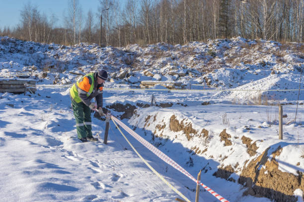 istock A worker at a construction site shields trenches with a signal tape for cadastral surveying. 1077940684
