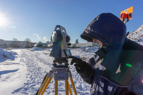 istock A surveyor enters the survey data for a cadastre at a construction site during the winter period. 1077940712