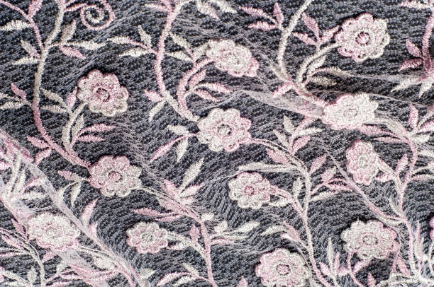 istock Texture, background, pattern. Pink lace decorated with flowers on a black background. Lace decorated with a pattern and decorative rose on a black background. 1077946844
