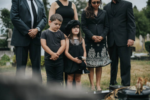 sad grandkids standing by the grave - cemetery child mourner death imagens e fotografias de stock