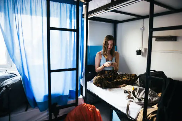 Backpacker using her phone in a hostel at Varanasi, India