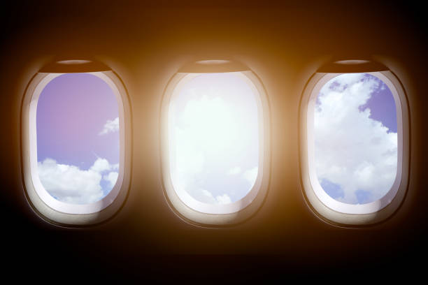 istock Three windows of the airplane that see the sky and clouds. 1077957664