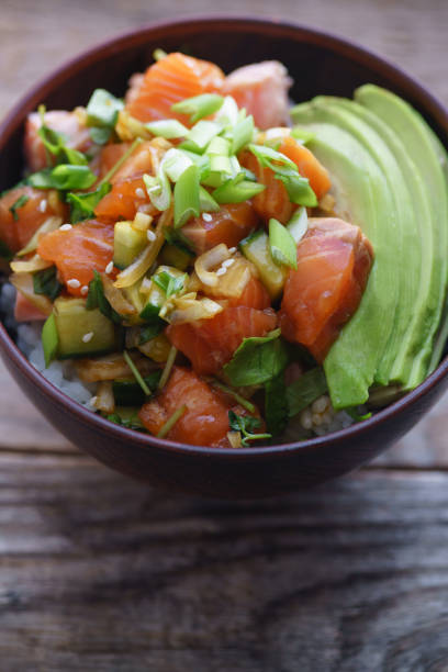 istock Poke bowl with raw marinated salmon, cucumbers and avocado. Macro shot 1077958170