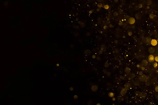 Golden glitter falling sparkle background on black border composition