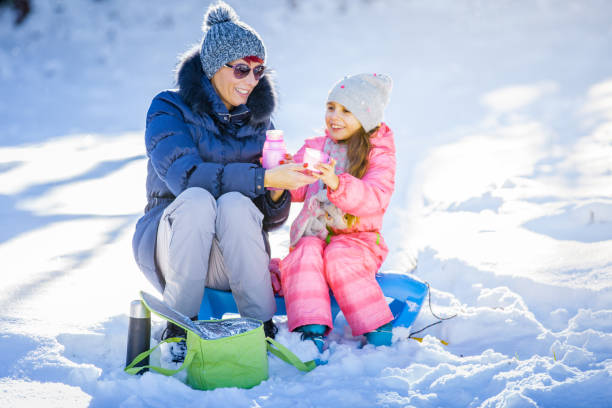 istock Mother and Daughter Enjoying and Taking a Break on Snow 1077965584