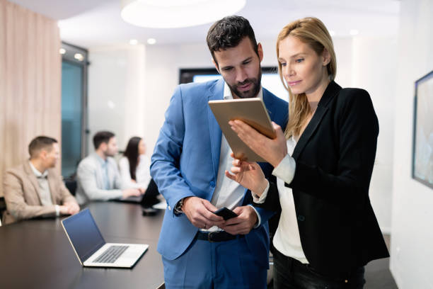 istock Attractive business couple using tablet in modern office 1077965918