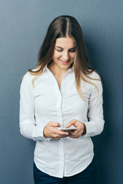 istock Young woman wearing white shirt using phone 1077969216