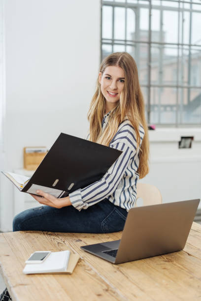 istock Smiling businesswoman working from a binder 1077972332