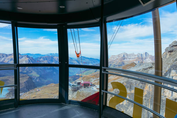 View from a gondola of the Rotair overhead cable car on Mt. Titlis in Switzerland Mt. Titlis, Switzerland - October 12, 2015: view from a gondola of the Rotair overhead cable car. Rotair is an overhead cable car on Mt. Titlis, its gondolas make a 360-degrees turn during the five-minutes trip. The Titlis is a mountain, located on the border between the Swiss cantons of Obwalden and Bern, it is a popular tourist destination, mainly accessed from the town of Engelberg. engelberg photos stock pictures, royalty-free photos & images