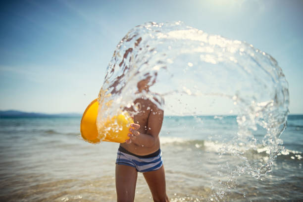 Boy on a sandy beach, enjoying large waves, Bali, Indonesia