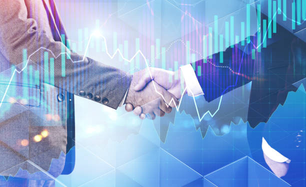 istock Handshake of businessmen, glowing graphs interface 1077977956