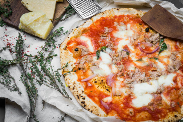 istock Neapolitan tuna pizza with mozzarella, arugula, tomato and thyme. Top view 1077978276