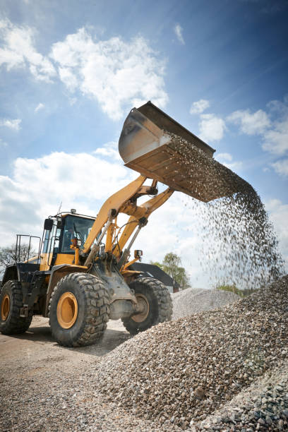 escavatore che muove la sabbia in una fossa di ghiaia - caterpillar truck foto e immagini stock