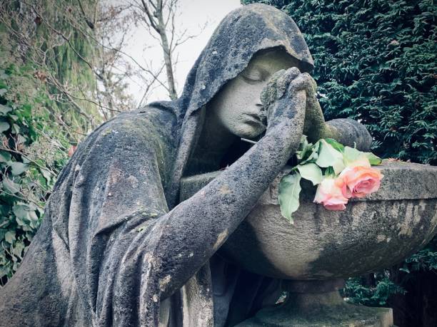 istock Woman statue on a tomb, praying 1077987798