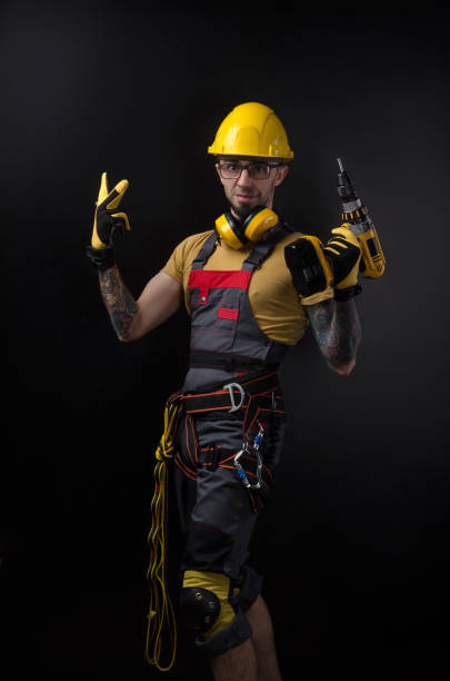 istock a young man posing on a black background in a work uniform and a construction tool 1077991186