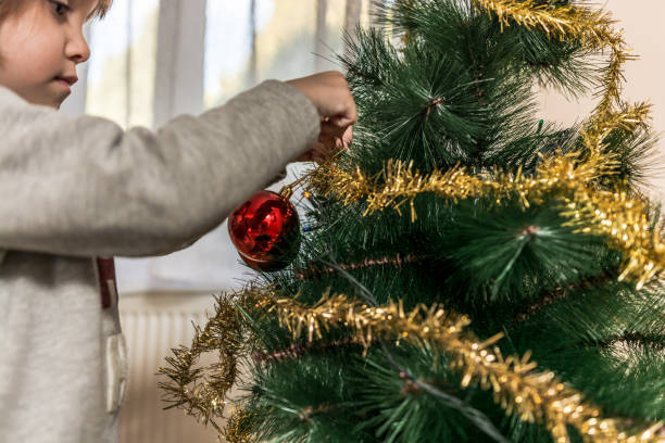 istock Cute little girl decorating christmas tree 1077994562