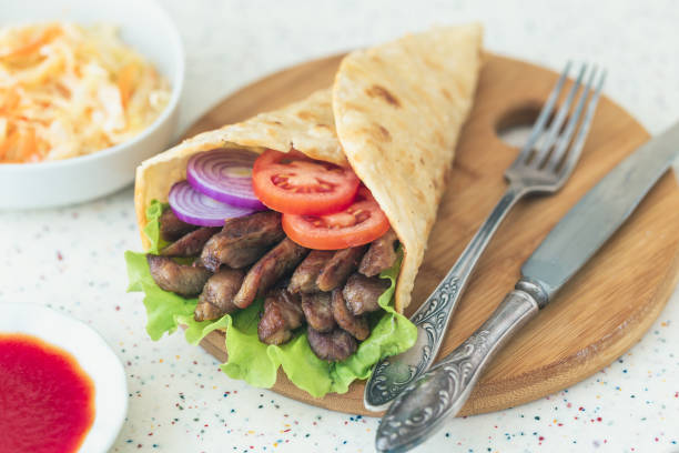 istock Handmade shawarma is lying on the white table made of artificial stone 1077996118