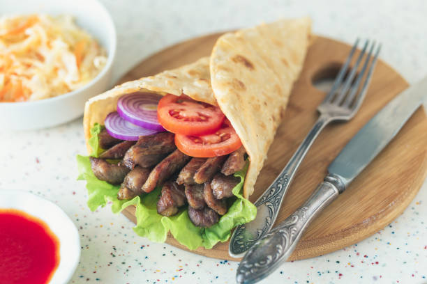 istock Handmade shawarma is lying on the white table made of artificial stone 1077996170