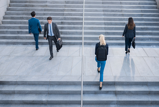 Businessmen and businesswomen walking on stairs at outdoors.