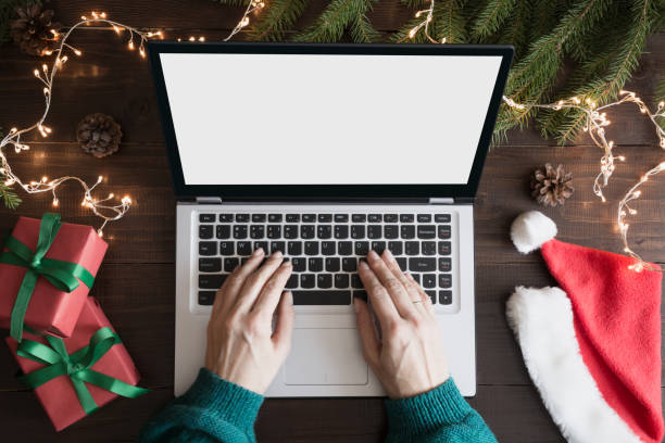istock Woman typing and searching by laptop. Space for text on screen. Top view on keyboard, human hands, Christmas gift on wooden board. Holiday concept. Xmas. 1077996842