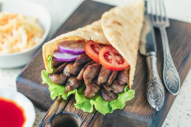 istock Handmade shawarma is lying on the white table made of artificial stone 1077997974